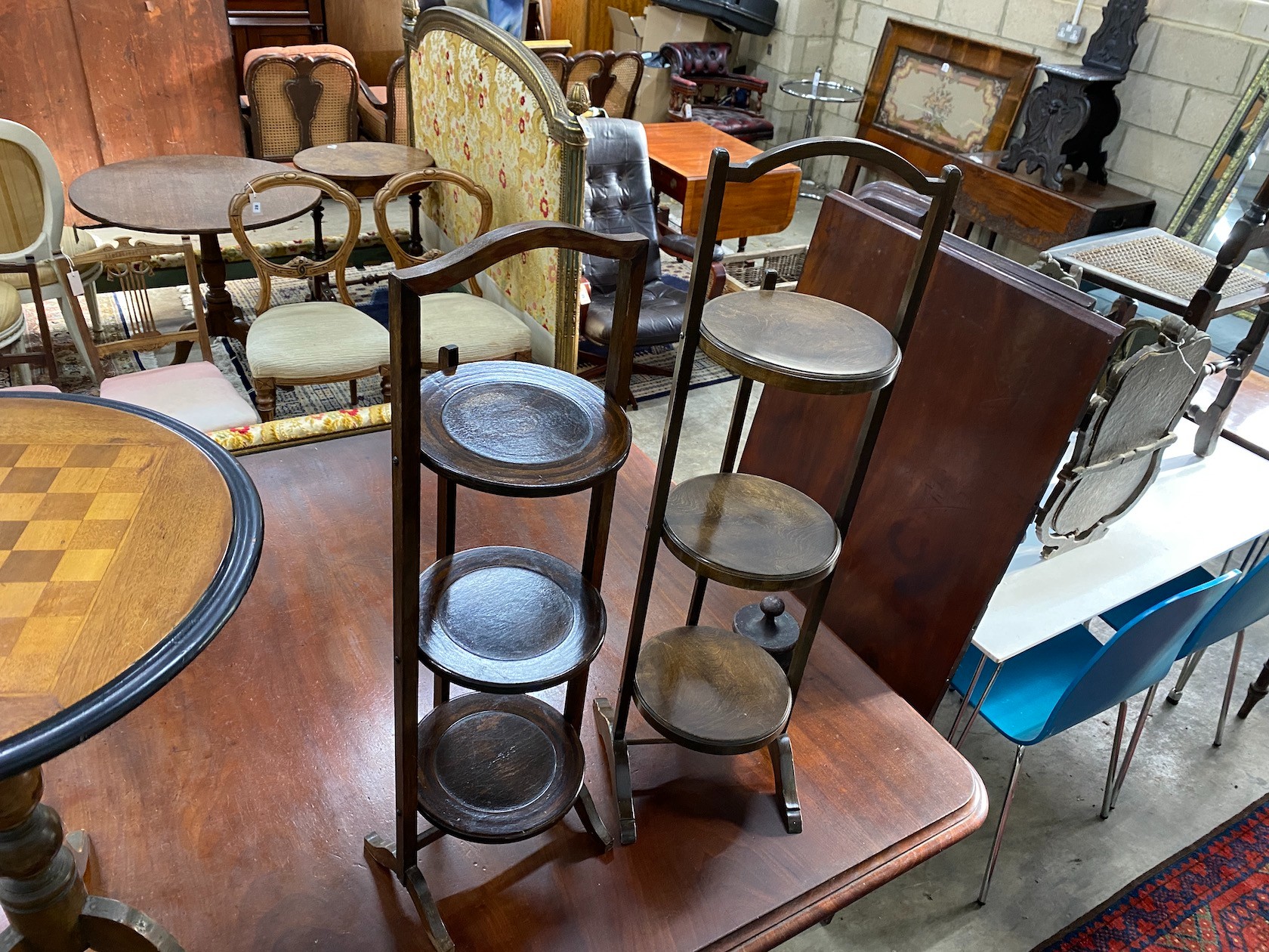 A Victorian style circular tripod games table, diameter 51cm, height 66cm together with three cake stands